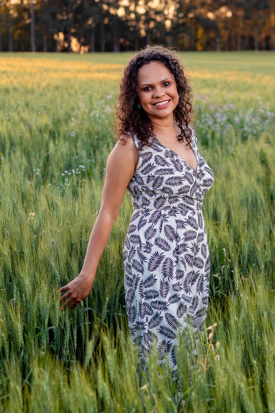 Thassiana em um campo ao pôr do sol